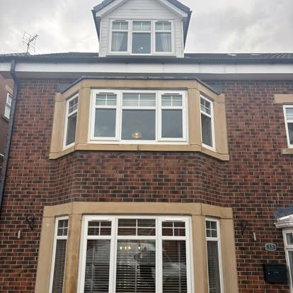 Freshly cleaned brick house with bright white UPVC bay windows